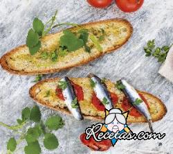 Bruschetta de pan integral con anchoas, tomate asado y perejil fresco